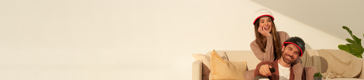 Image banner of a man wearing the Elite device and a woman wearing the Professional device sitting on a couch.
