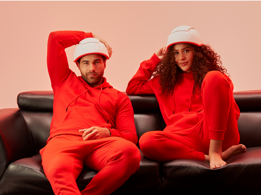 Man and woman wearing the Professional Device while sitting on a couch.