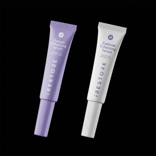 Two tubes of iRestore eyelash and eyebrow enhancing serums on a black background