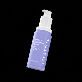 Vitamin C Brightening Serum bottle with white pump on a black background