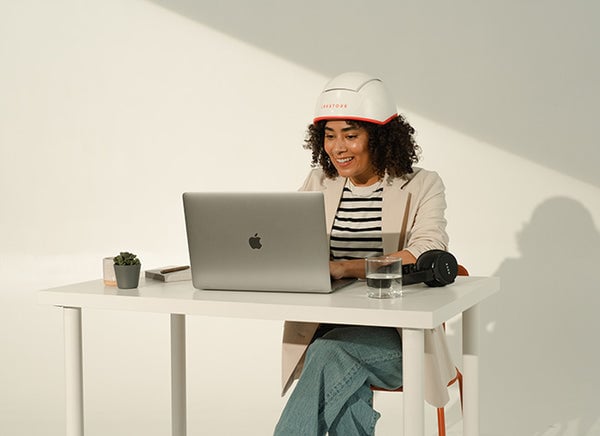 Image of a woman wearing the Professional hair device in a work from home set up.