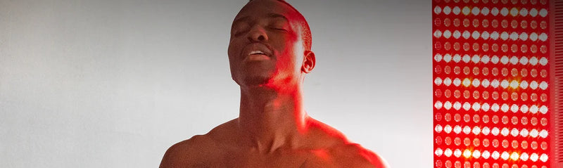 Man receiving red light therapy on a gray background