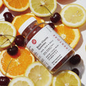 Bottle of biotin gummies on top of fruits and gummies