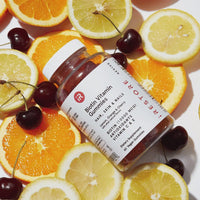 Bottle of biotin gummies on top of fruits and gummies