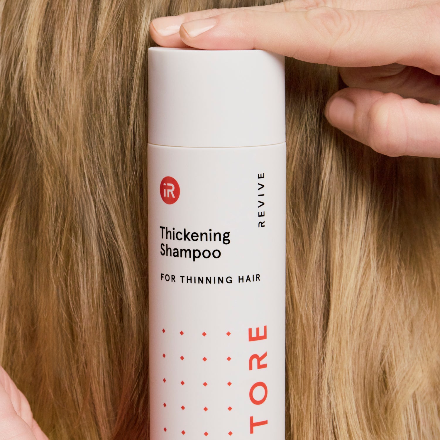 woman holding a shampoo bottle behind her head