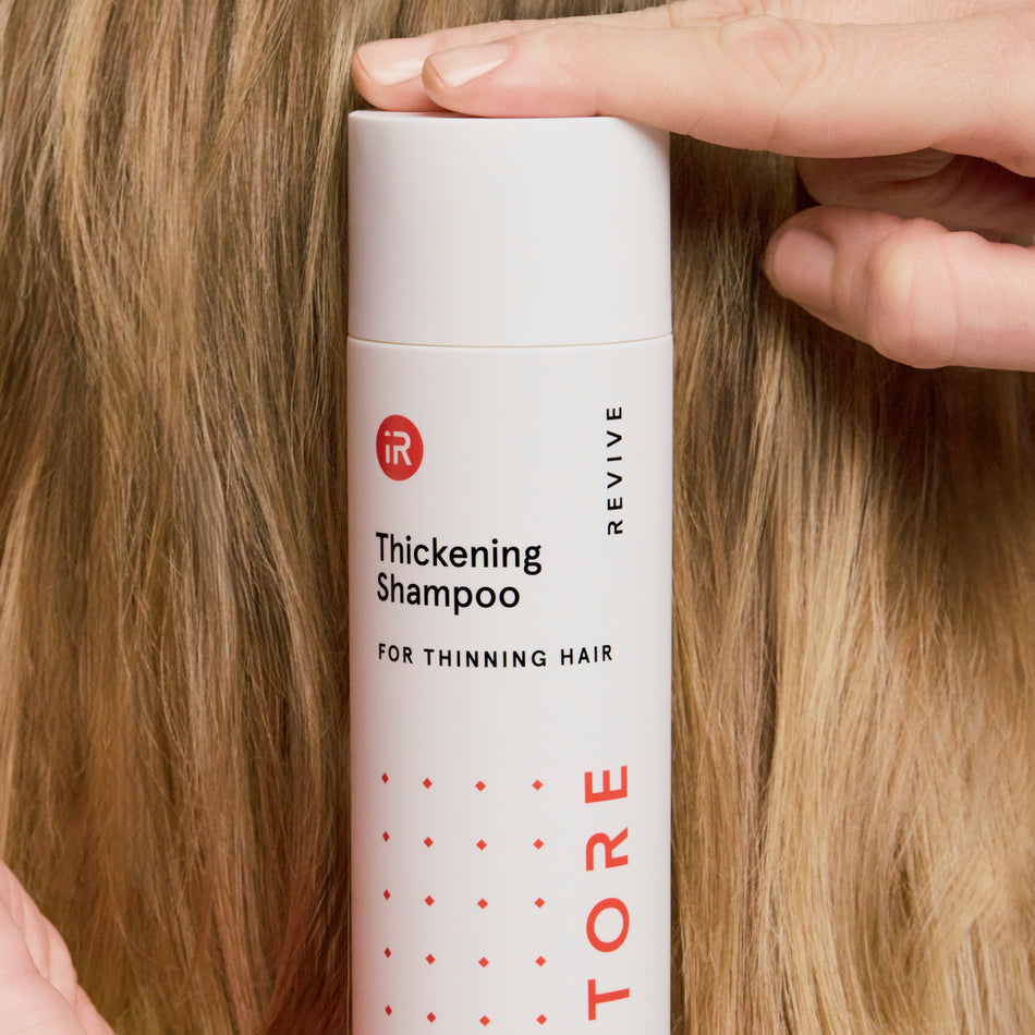 woman holding a shampoo bottle behind her head