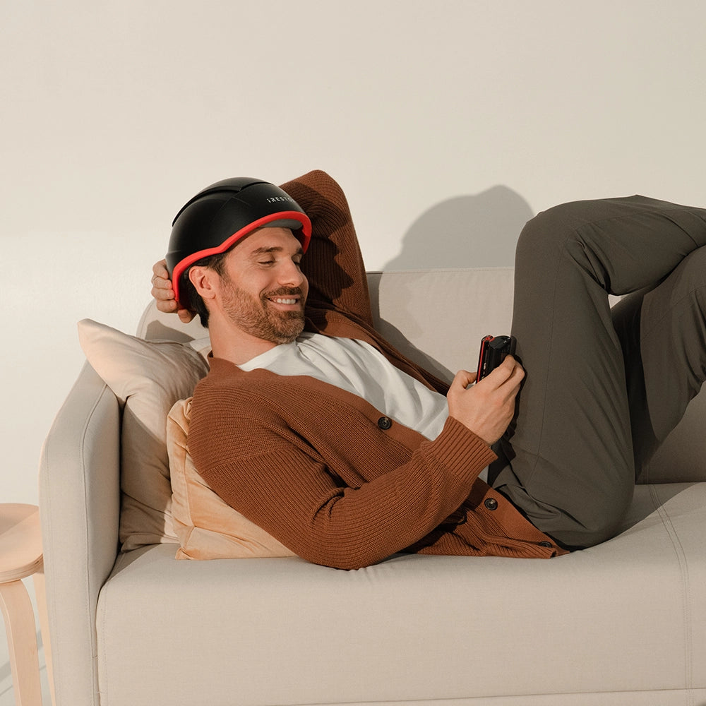 Model wearing iRESTORE Elite while laying on sofa
