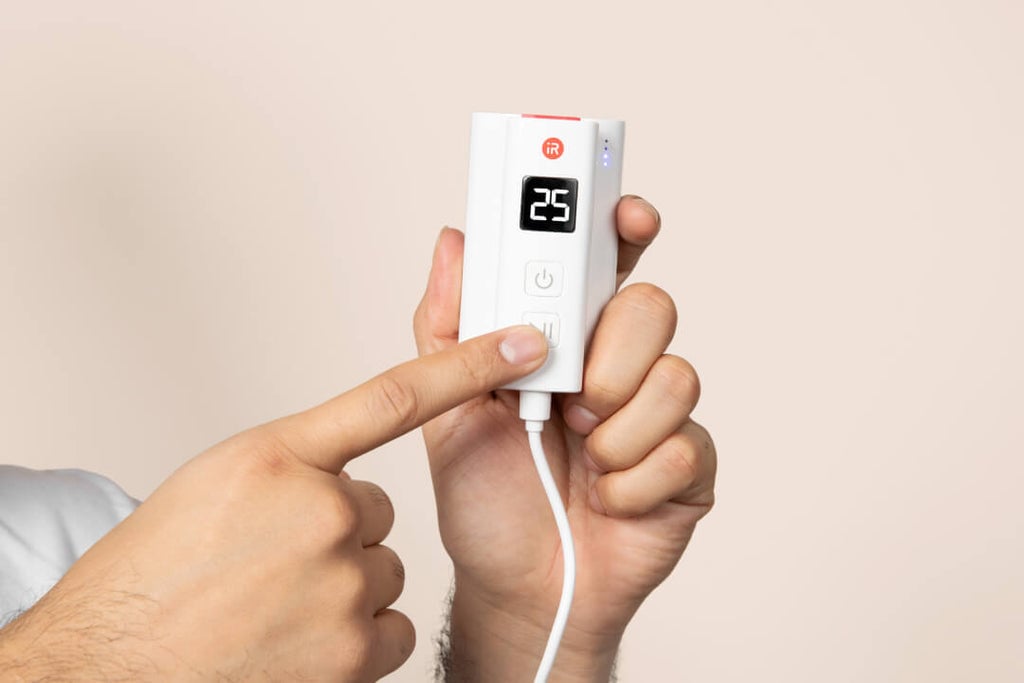 Hand holding the iRESTORE professional device remote.