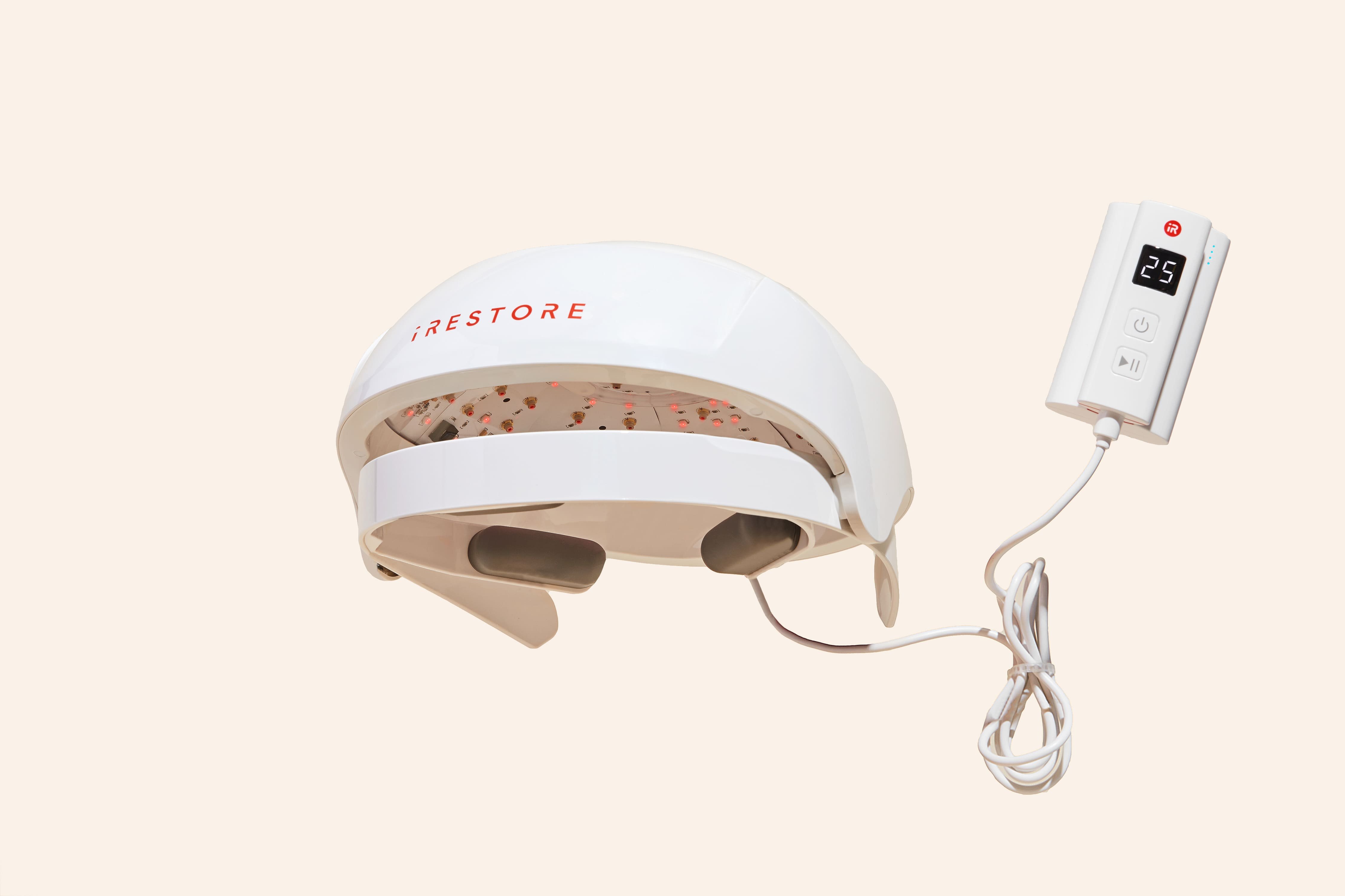 Hair restoration device with a control unit featuring an LED display and buttons.
