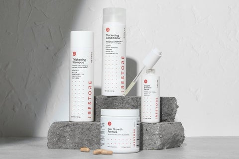 Image shows the REVIVE Max Growth Kit. Includes the Thickening Shampoo and Conditioner, Growth Activator Serum and Hair Growth Formula with rocks in the background.