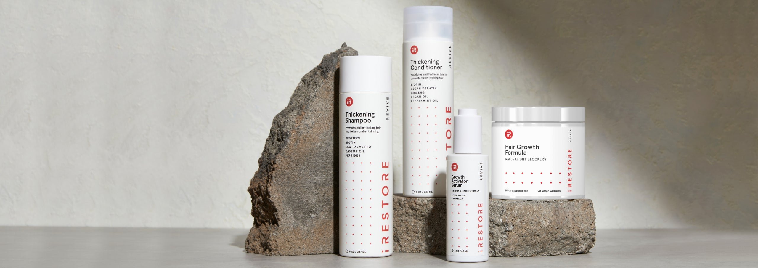 Image shows the REVIVE Max Growth Kit. Includes the Thickening Shampoo and Conditioner, Growth Activator Serum and Hair Growth Formula with rocks in the background.