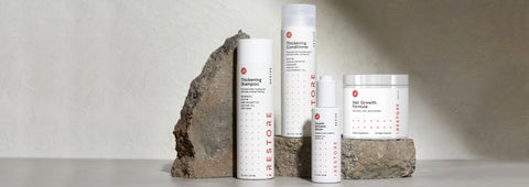Image shows the REVIVE Max Growth Kit. Includes the Thickening Shampoo and Conditioner, Growth Activator Serum and Hair Growth Formula with rocks in the background.