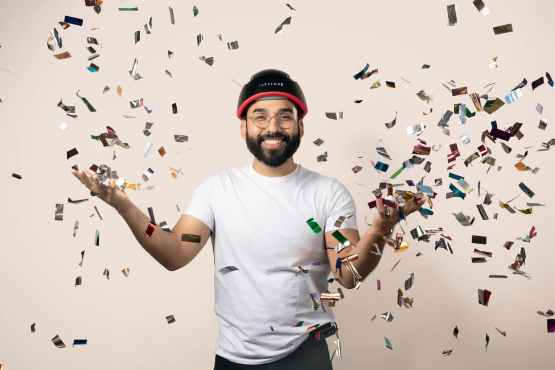 Image shows a man wearing the Elite device while throwing confetti around him.