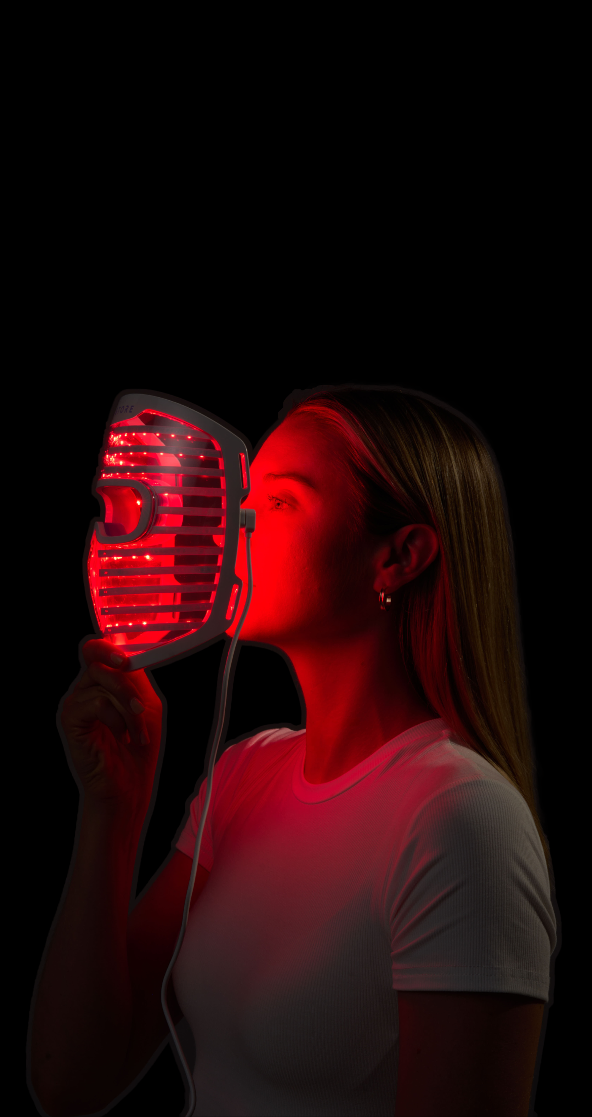 Person wearing a futuristic mask with red lights on a purple background.