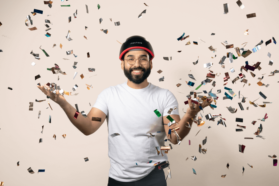 Image shows a man wearing the Elite device while throwing confetti around him.