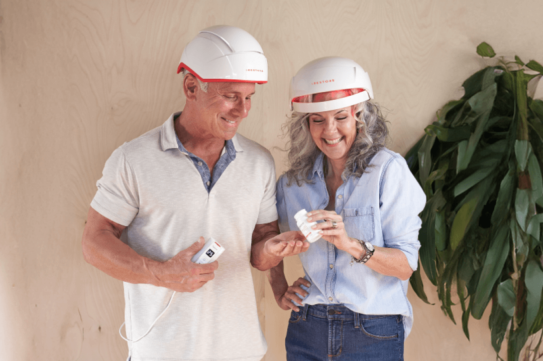 Mature man wearing the pro device standing beside a mature woman wearing the essential device.