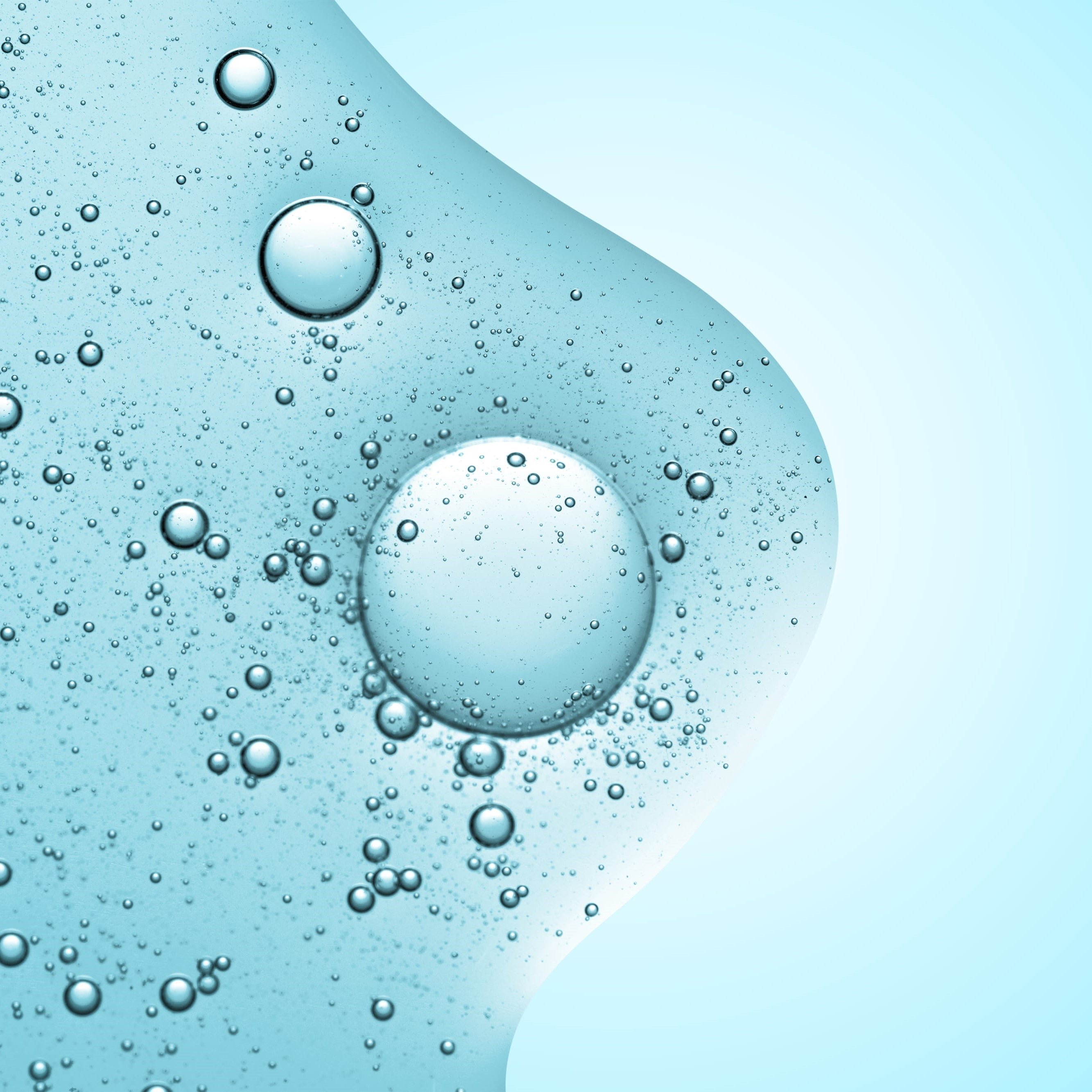 Close-up of bubbles in a light blue liquid.