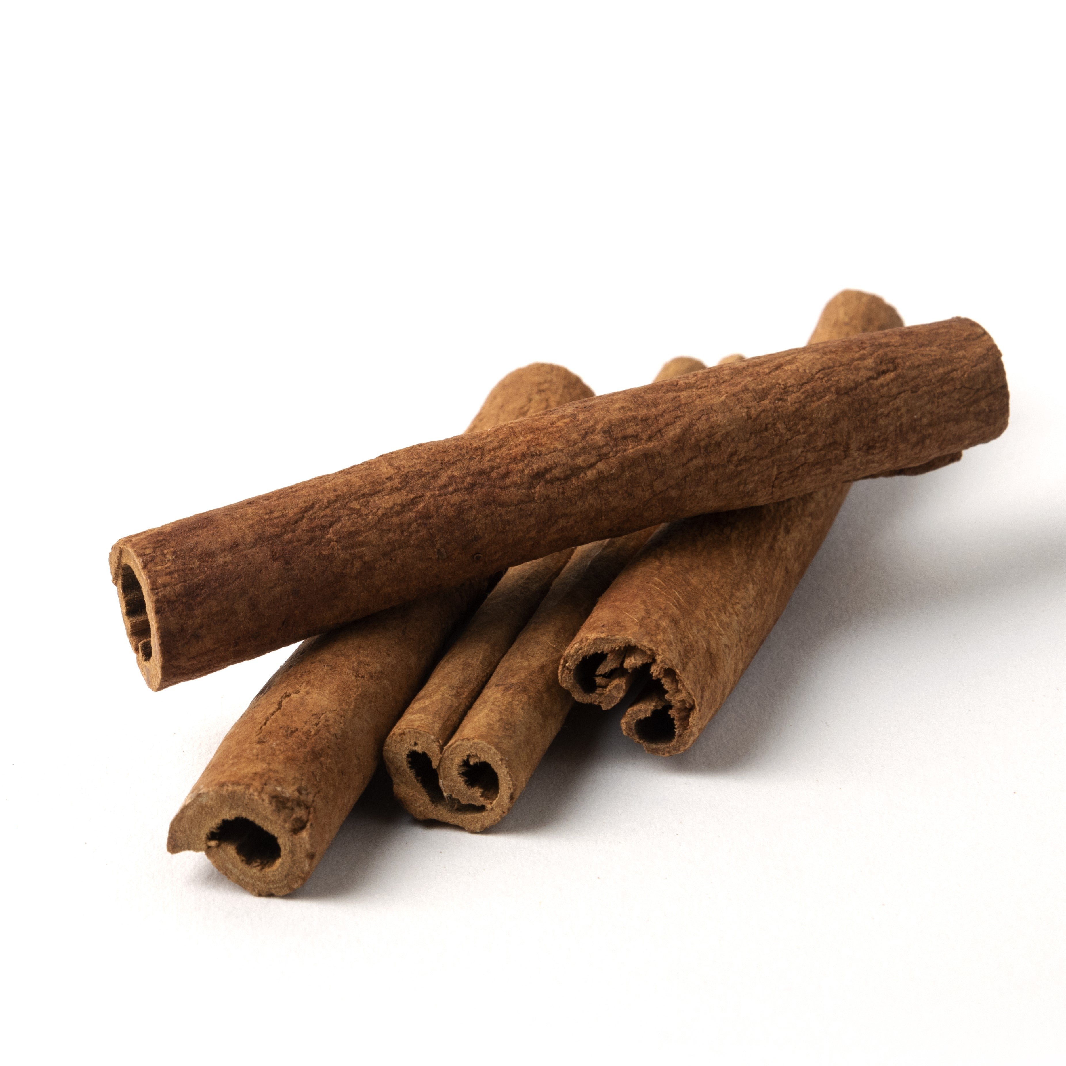 Five cinnamon sticks arranged against a white background.