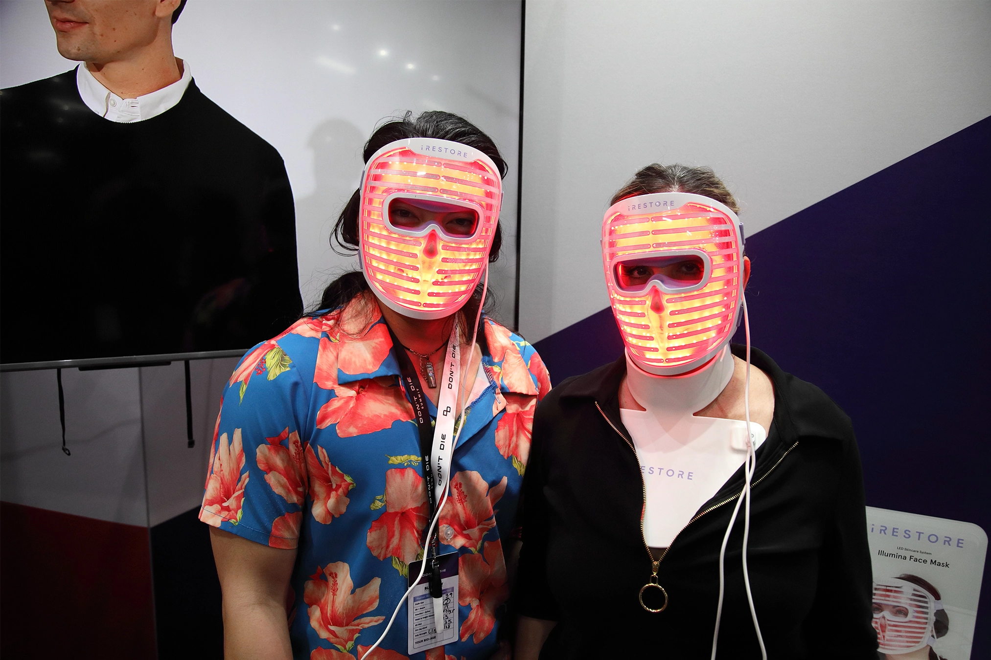 Two attendees trying out the iRESTORE face mask