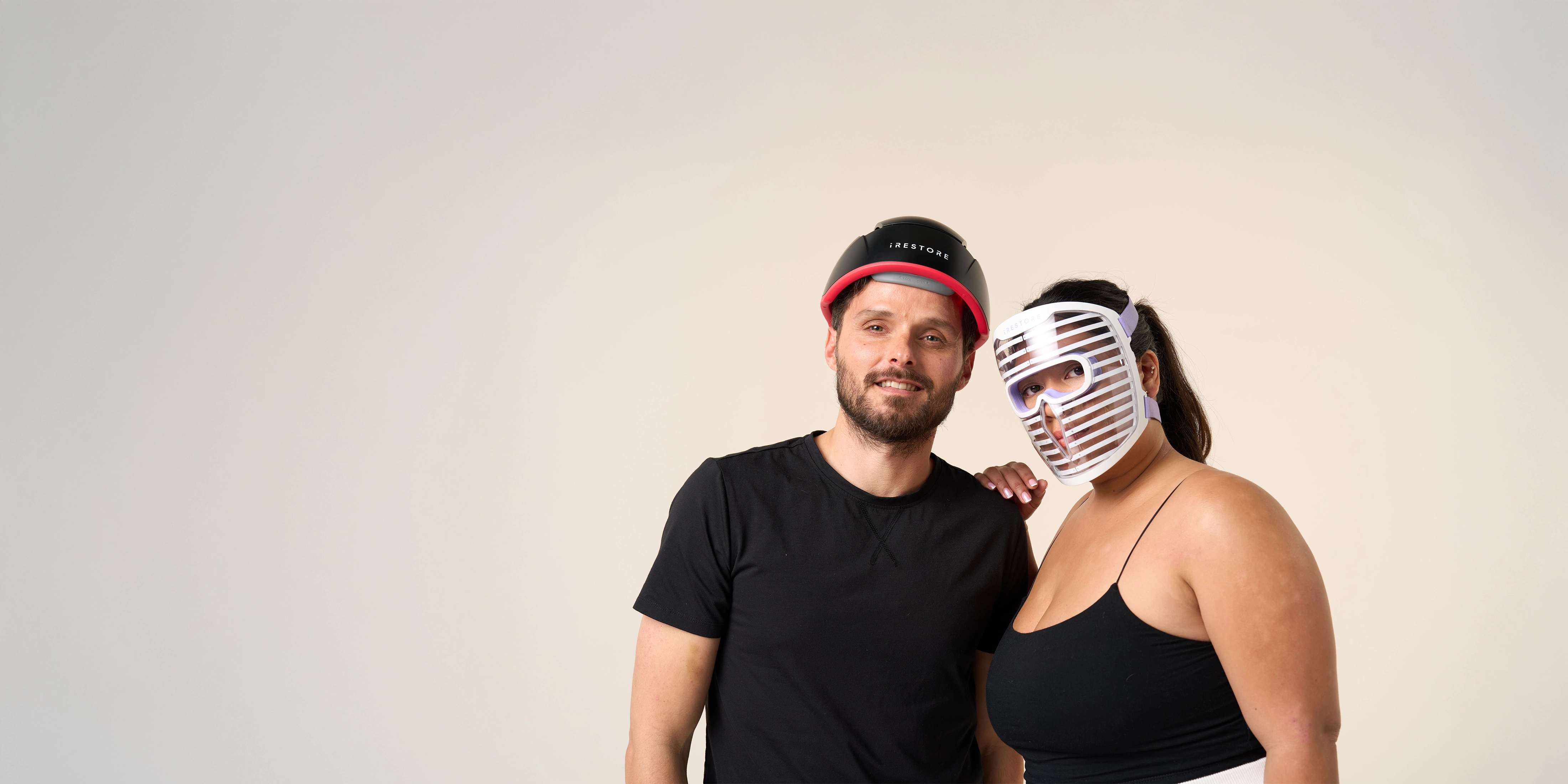Man wearing iRESTORE Elite and woman wearing Illumina Face Mask