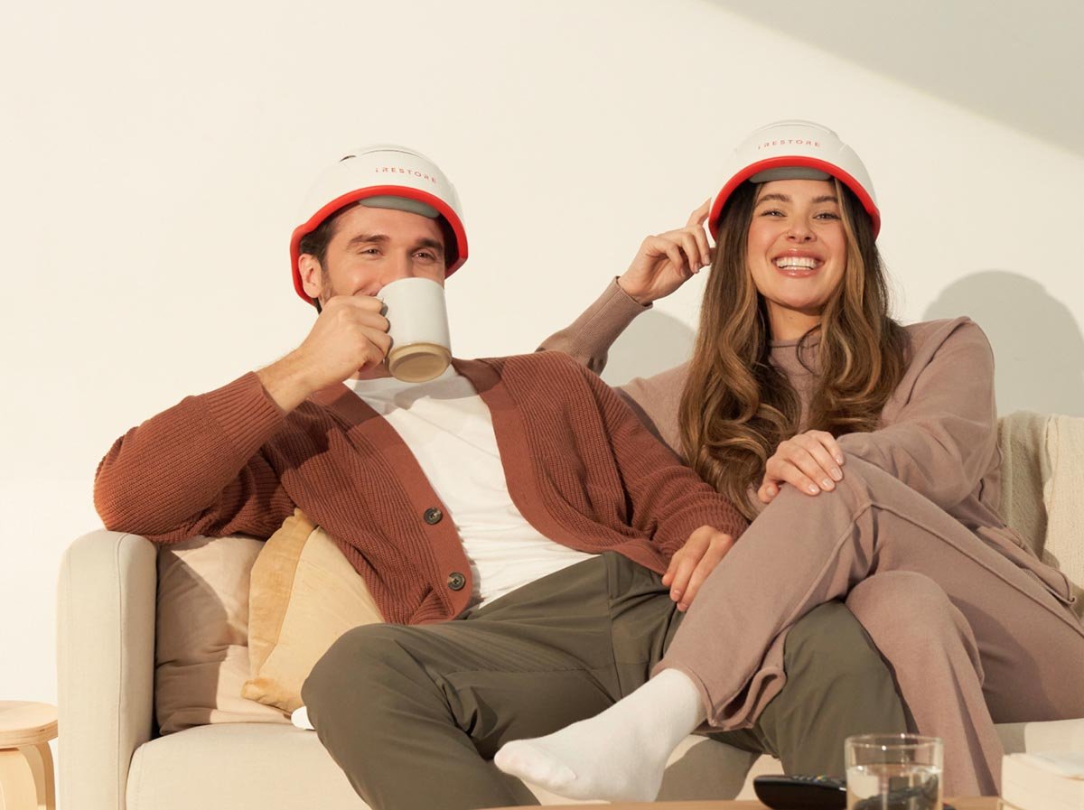 Image of a man and woman wearing the Professional Device sitting on a couch.