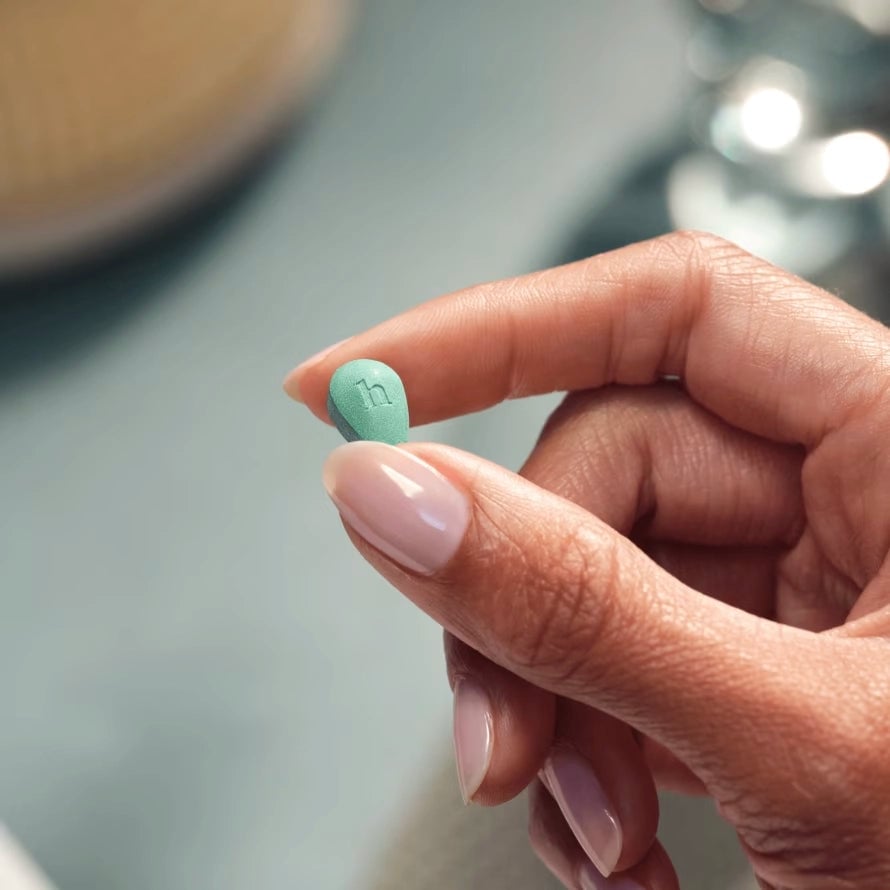 hers vitamin and minoxidil in hand